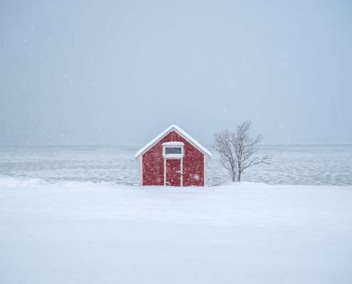 Eine rote Hütte in schneebedeckter Landschaft